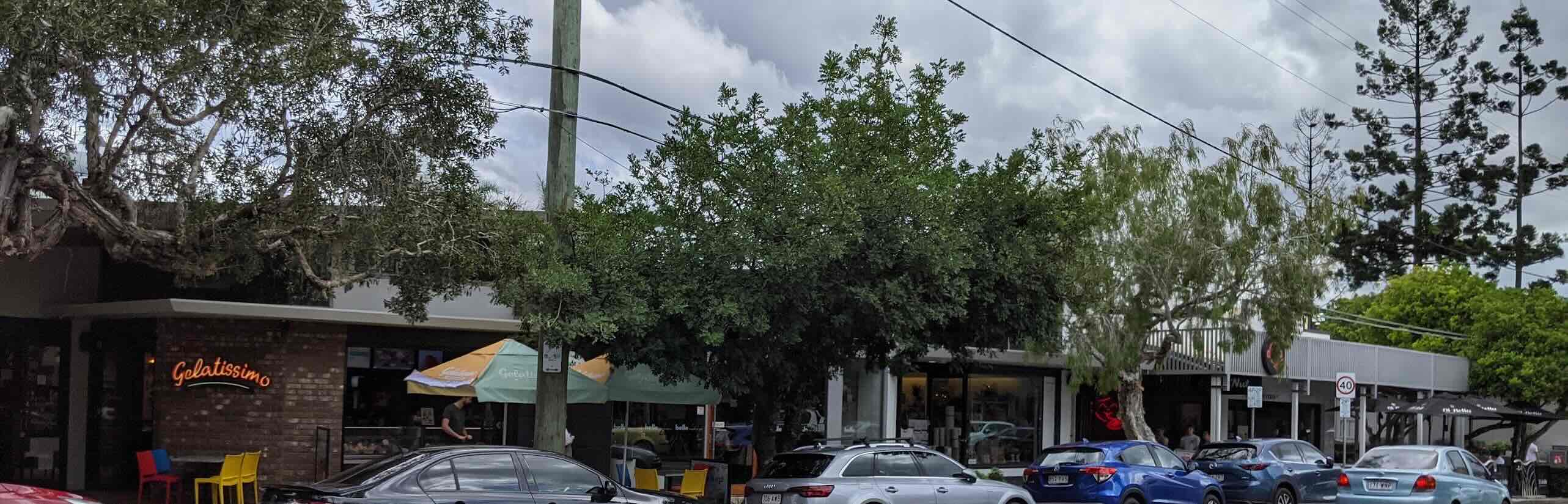 Shops on Oxford St Bulimba with trees in front.